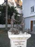 Statue of a butcher and a farmer shaking hands over some pigs