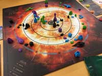 Board game with ships and structures in and around the sun.