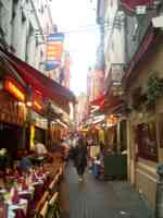Narrow street lined with restaurants and signs