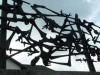 Huge metal sculpture of emaciated humans thrown onto a barbed-wire electric fence