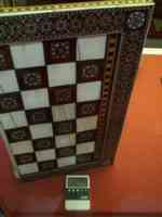 Old chess board with electronic device monitoring temperature inside exhibit case