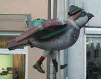 Sculpture of sparrow with backpack, hiking boots and socks, and a hat