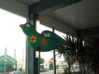 Green sparrow sculpture decorated with flowers and a heart