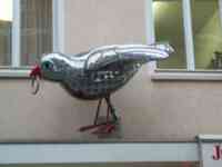 Shiny sculpture of a sparrow with a ring in its beak