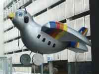 Sparrow statue with wheels, headphone and microphone, tailfin, windows, silver body, and painted stripes