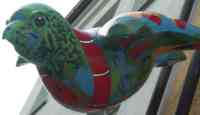 Sculpture of sparrow painted with flags in shapes of land masses on a globe