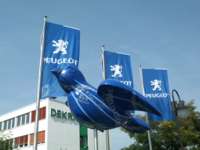 Blue sparrow sculpture with white streamlines and "Peugeot" lettering