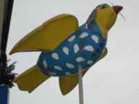 Yellow sparrow sculpture wearing nightcap and sky-blue robe with white clouds