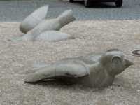Four sparrow sculptures embedded in the ground in various poses