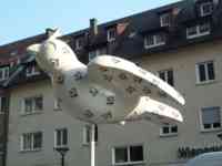 White sparrow sculpture decorated with abstract black sparrow symbols