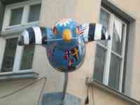 Sculpture of blue sparrow painted with flags in shapes of land masses on a globe