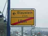 Road sign with arrow pointing to Blaustein and with Ulm crossed out