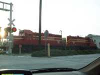 Two locomotives passing through a railroad crossing